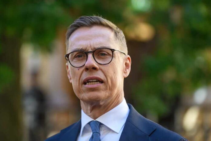 A man in a suit speaking outdoors with a serious expression