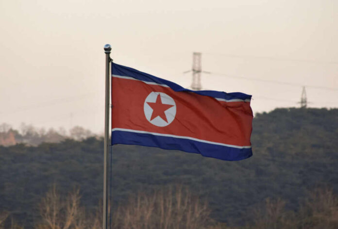 shutterstock_2511630583-1 North Korean flag waving against a mountainous backdrop