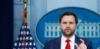 Government official speaking at a press conference in front of the White House