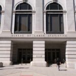 Facade of the Bureau of Labor Statistics building with a person walking by