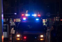 High Court Panic: Swatting Strikes Again Emergency vehicle with flashing lights in a busy urban area at night