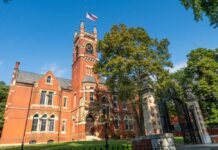 Historic red brick building with a clock tower and American flag