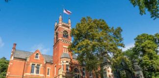 Historic red brick building with a clock tower and American flag
