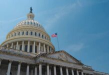 Billion-Dollar Payout Mystery: Taxpayer Cash at Risk? The U.S. Capitol building with an American flag flying against a blue sky