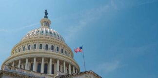 Billion-Dollar Payout Mystery: Taxpayer Cash at Risk? The U.S. Capitol building with an American flag flying against a blue sky