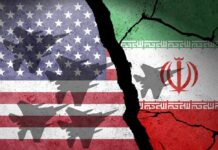A cracked wall featuring the flags of the USA and Iran with military aircraft silhouettes