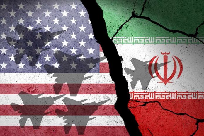 A cracked wall featuring the flags of the USA and Iran with military aircraft silhouettes