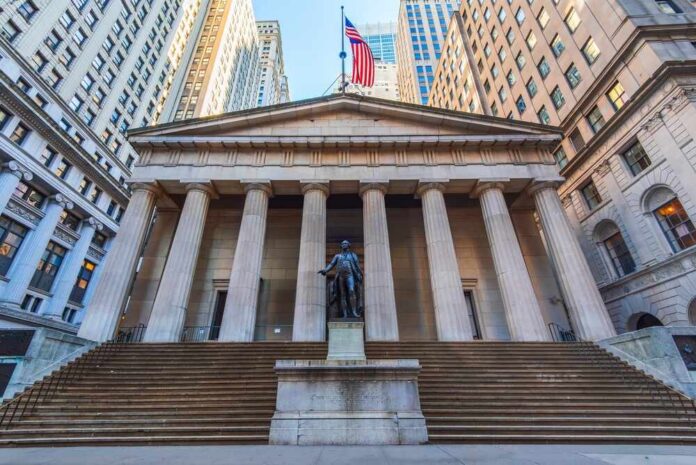 Historic building with columns and a statue in front, featuring an American flag