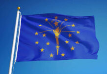 Indiana state flag waving against a blue sky