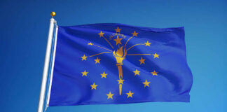 Indiana state flag waving against a blue sky