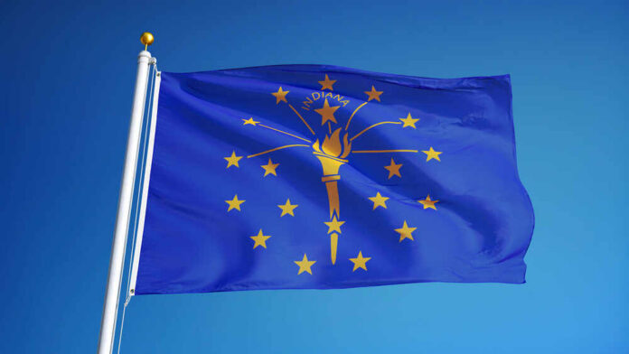 Indiana state flag waving against a blue sky