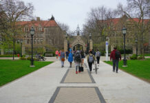 Dorm Predator Still Loose — Parents Revolt Students walking along a pathway on a university campus with historic buildings in the background