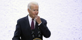 Biden Returns Swinging At Trump A man in a suit speaking at a podium with a presidential seal