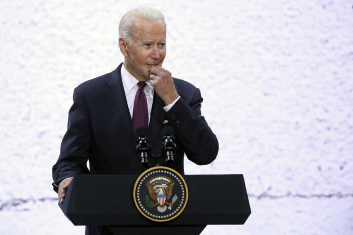 A man in a suit speaking at a podium with a presidential seal