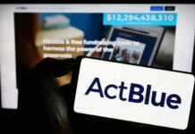 ActBlue Shielded — But What’s Hiding Underneath? A hand holding a mobile device displaying the ActBlue logo in front of a blurred screen showing fundraising information