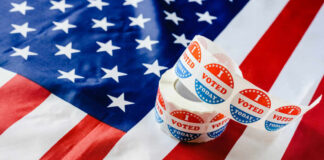 Four Republicans Torch Voter ID Push Voting stickers on an American flag background