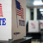 Officials Dispute Fraud Claims In LA Voting booths with American flags in a polling station