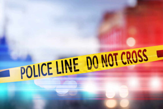 Yellow,Law,Enforcement,Tape,Isolating,Crime,Scene.,Blurred,View,Of Yellow police tape reading DO NOT CROSS at a crime scene