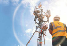 Labor Ban Backfires — Chaos Hits Both Sides Telecommunication worker in safety gear standing near a cell tower under a blue sky