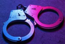 Daycare Horror Sparks Homicide Case Close-up of metallic handcuffs illuminated with neon lights