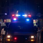 Teen Killed, Case Stalls—What’s Missing? Emergency vehicle with flashing lights in a busy urban area at night