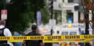 Active Shooter — What Happened In Midland, Texas? Police officers near a crime scene marked by caution tape