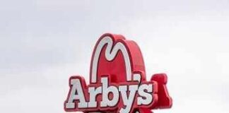 Arby's restaurant sign with cowboy hat logo on a pole