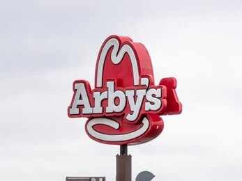 Arby's restaurant sign with cowboy hat logo on a pole
