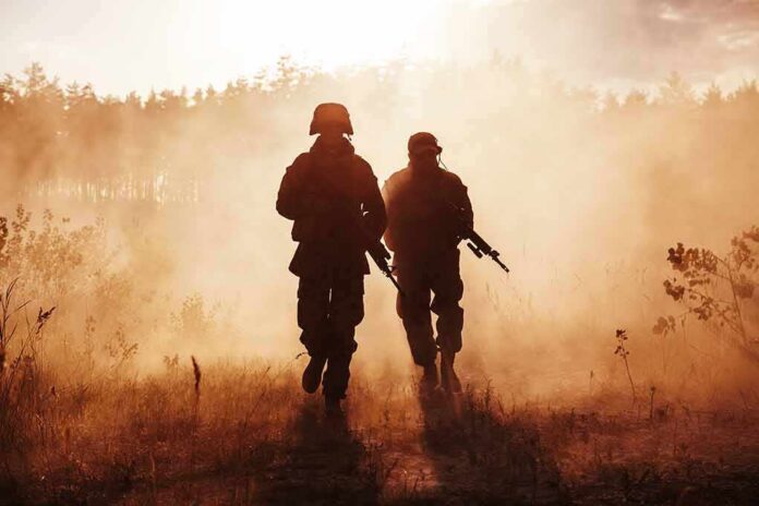 shutterstock_1069835897 Two soldiers walking through a smoky field at sunset