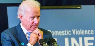 Biden Tapes Drop — What’s Hidden? man at podium speaking with hands clasped near chin