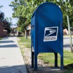USPS As Ballot Gatekeeper? Blue USPS mailbox on a suburban sidewalk