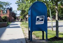 USPS As Ballot Gatekeeper? Blue USPS mailbox on a suburban sidewalk