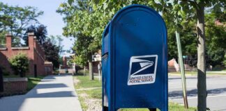 USPS As Ballot Gatekeeper? Blue USPS mailbox on a suburban sidewalk