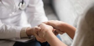 Doctor holding patient’s hands in support