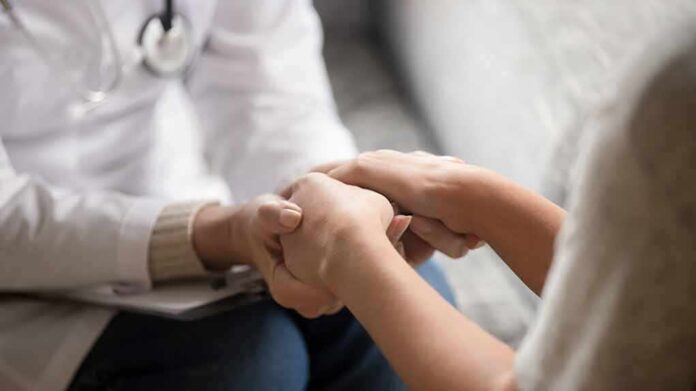 Doctor holding patient’s hands in support