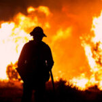 Deadly Spain Wildfire Kills At Least 11 Silhouette of a firefighter standing in front of a large wildfire
