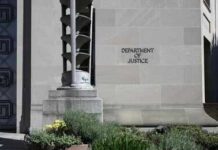 Department of Justice building exterior with stone facade and plants