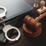 Pardon Fury: Child Predator Walks? Handcuffs and a gavel on a desk with legal books