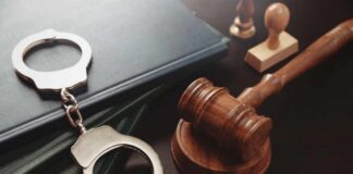 Pardon Fury: Child Predator Walks? Handcuffs and a gavel on a desk with legal books