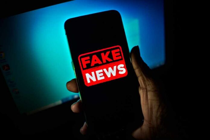 Hand,Holds,A,Smartphone,Where,The,Phrase,Fake,News,Appears Smartphone screen showing a bold fake news warning