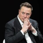 Musk’s Backup Plan Stalls man in a suit with hands clasped thoughtfully