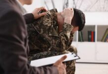 Veterans Try Controversial PTSD Treatment Soldier in camouflage sits with head in hands during counseling session