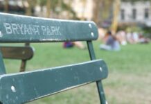 Parents Shocked After Baby Targeted Green metal park chair with people relaxing on a lawn in the background