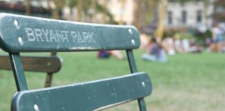 Parents Shocked After Baby Targeted Green metal park chair with people relaxing on a lawn in the background
