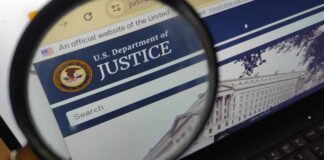 DOJ Subpoenas Air Force One Reporters Close-up view of the U.S. Department of Justice website through a magnifying glass