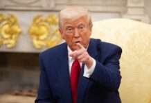 Trump’s New Spending Push Faces Resistance A man in a blue suit and red tie pointing while seated