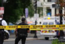 Dad Faces Murder Charge In Tragedy Police officers near a crime scene marked by caution tape
