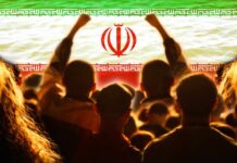 Crowd of people raising their fists in front of the Iranian flag
