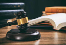 Judge Blinks As Costs Explode Judge's gavel on desk with open law book