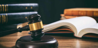 Judge Blinks As Costs Explode Judge's gavel on desk with open law book